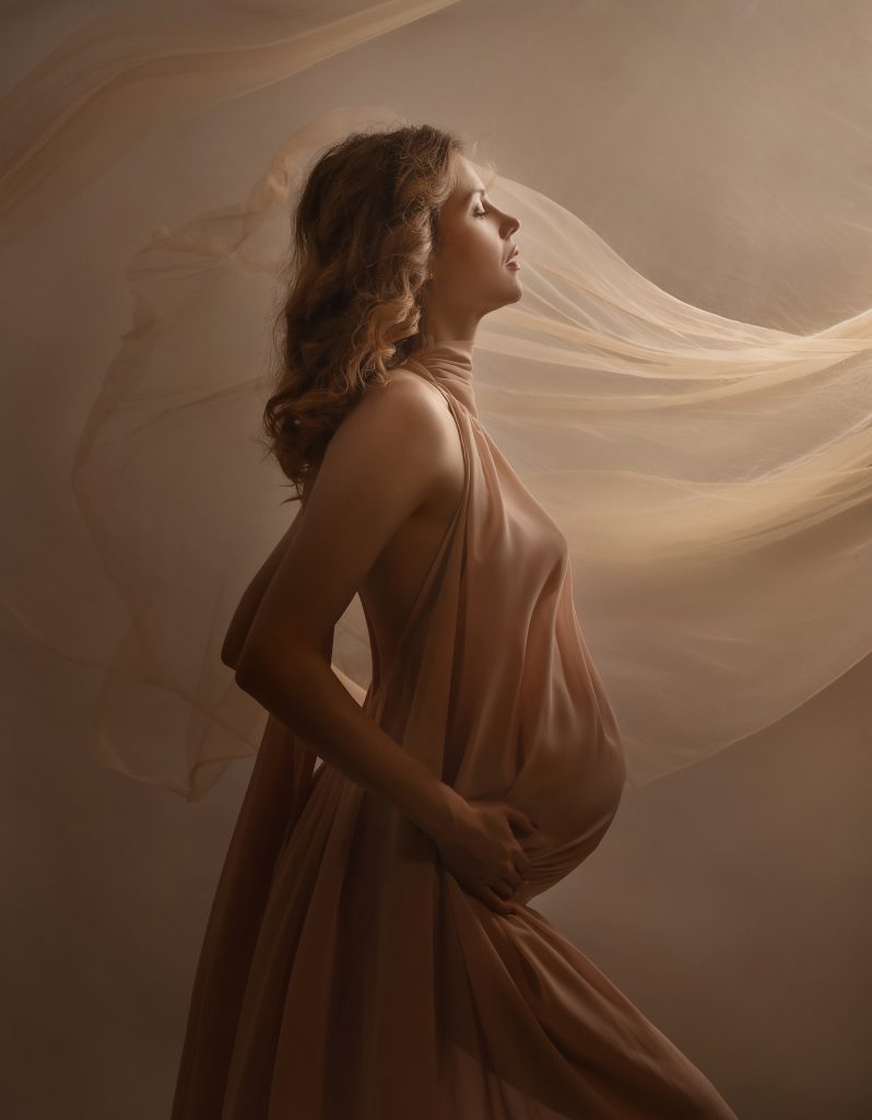 Pregnancy photoshoot in Sutton studio at 32 weeks wearing flowing maternity gown Sutton South London