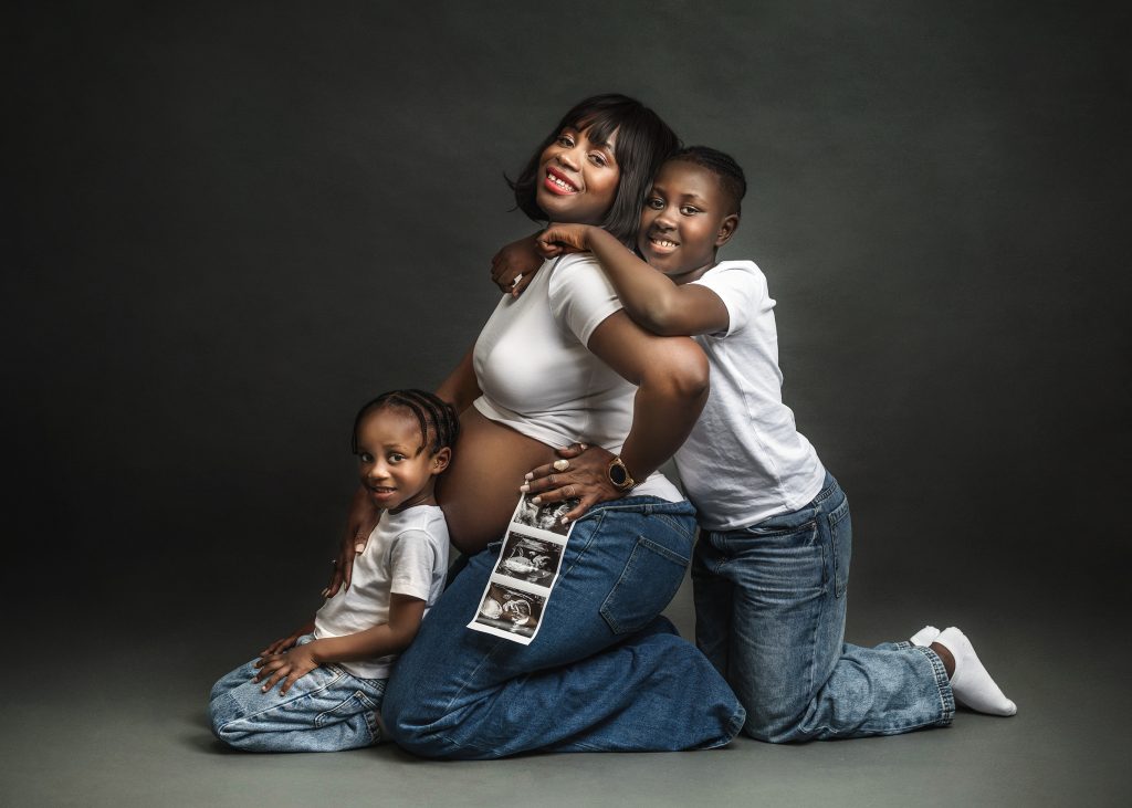 Family Pregnancy Studio Casual photography Pregnant lady holding baby scan picture children hugging and smiling
