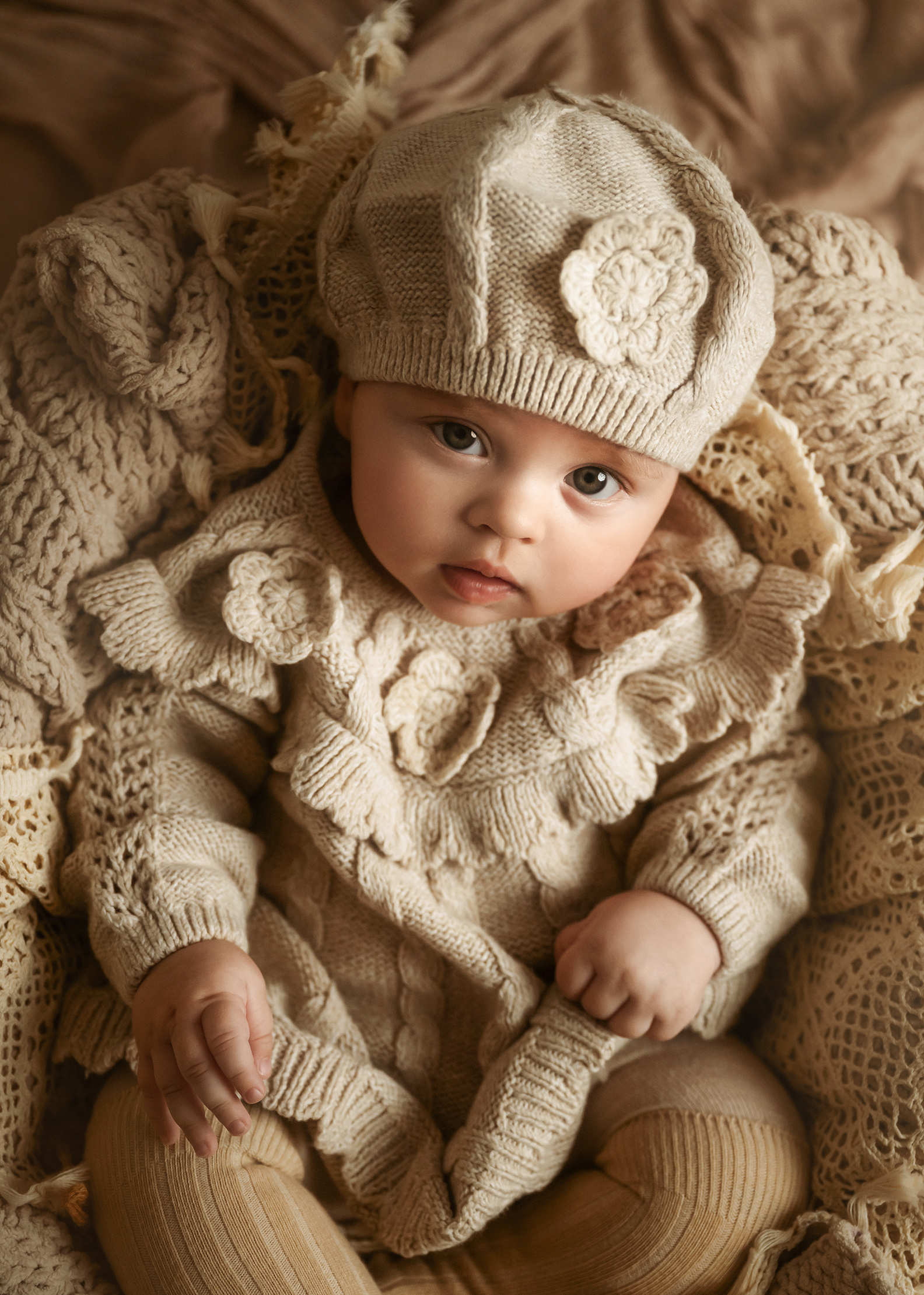 baby girl in home professional natural portrait baby laying in a natural colour blanket looking at the camera baby and family photoshoot in Sutton Surrey