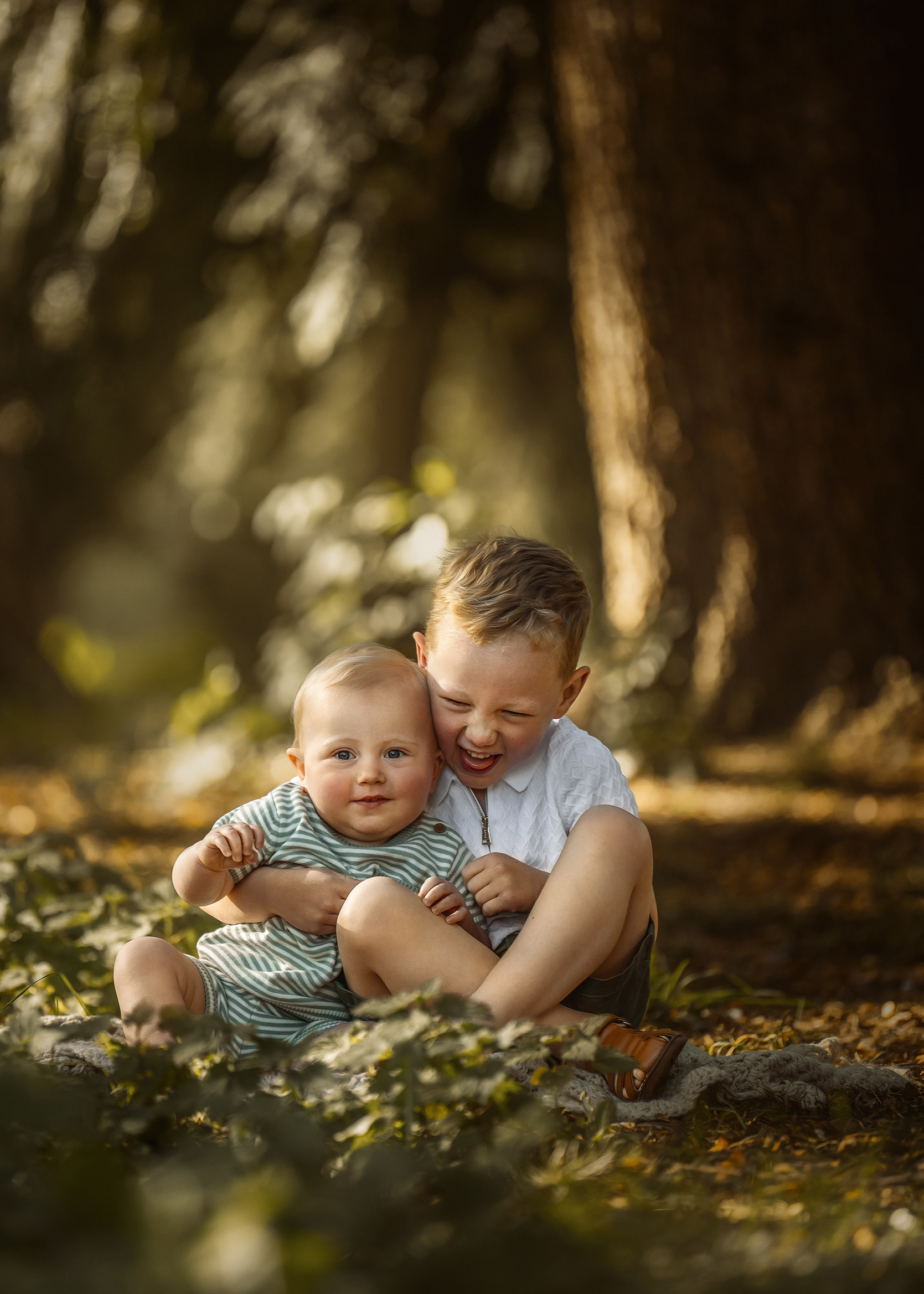 baby siblings children outdoors sitting hugging smiling natural emotions painterly photography family photographer in Sutton Surrey and London