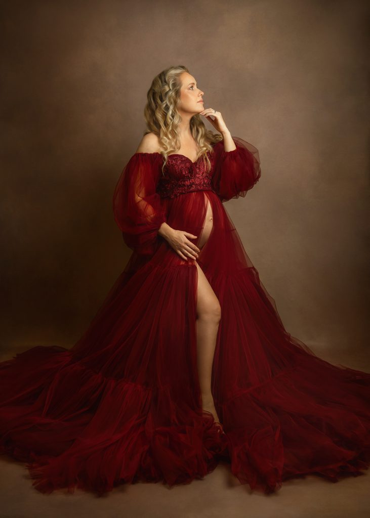 painterly fine art maternity studio photoshoot pregnant lady standing wearing red tulle dress posing in studio soft light Maternity photographer Sutton Surrey London