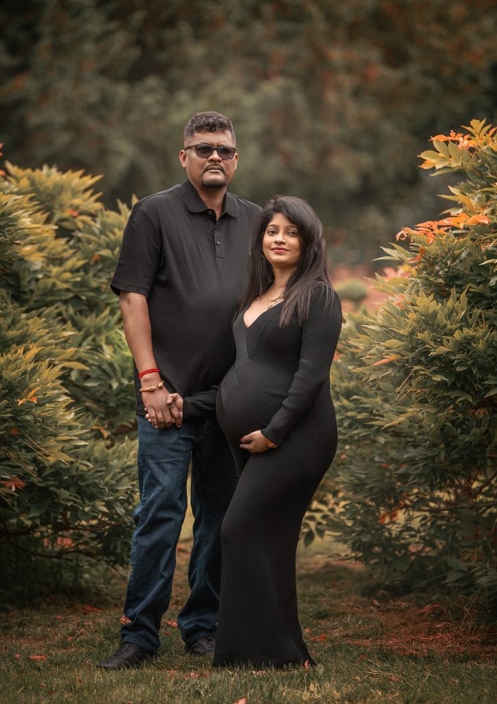 natural pregnancy photography relaxed couple pose wearing black belly showing dress holding partner's hand Cheam Nonsuch Park Surrey
