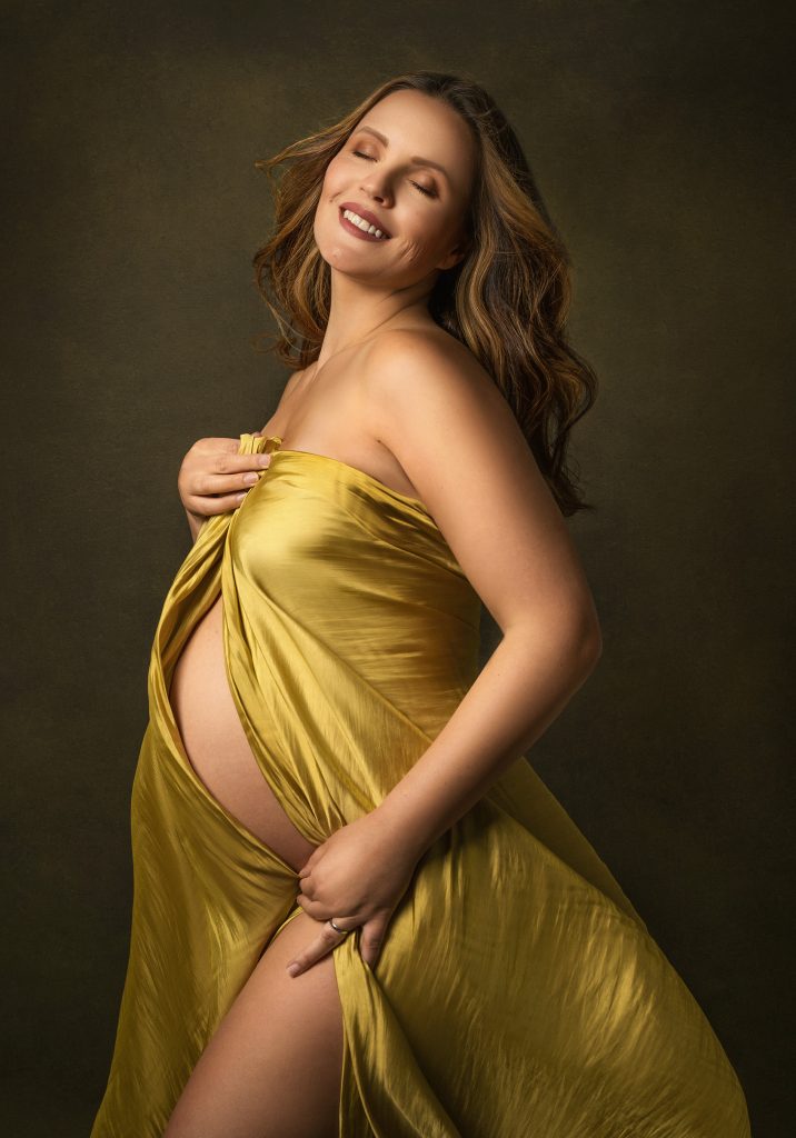 Elegant maternity studio close up pose lady smiling holding belly holding satin fabric classic Surrey South London photography