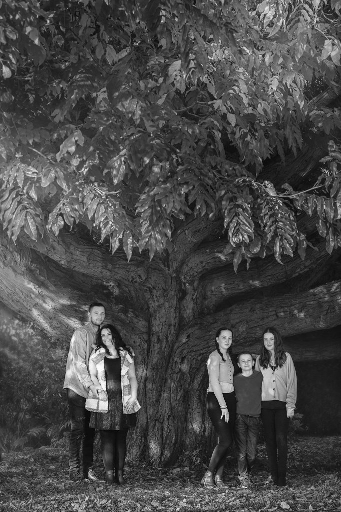 black and white family photo at the big tree all smiling and enjoying a relaxed pose Wallington, Beddington Park photoshoot