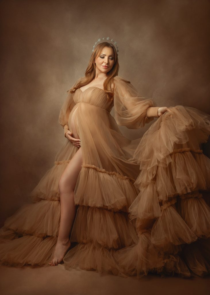dreamy studio pregnancy photo lady holding belly wearing big tulle beige dress Sutton Surrey photographer