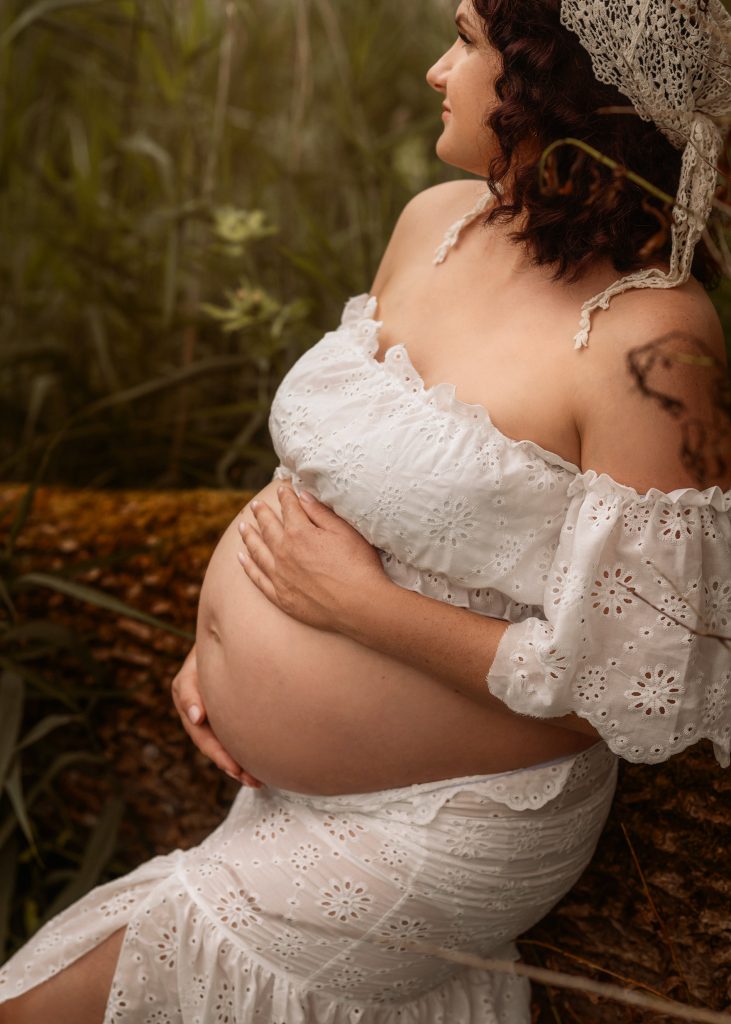 Close-up of expectant mother holding her baby bump during outdoor maternity photography session