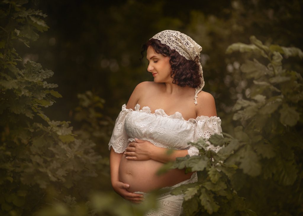 Expectant mother in white during beautiful outdoor maternity photography session in Surrey woodland